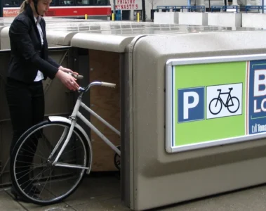 A cyclist places a bicycle in a City of Toronto bike locker