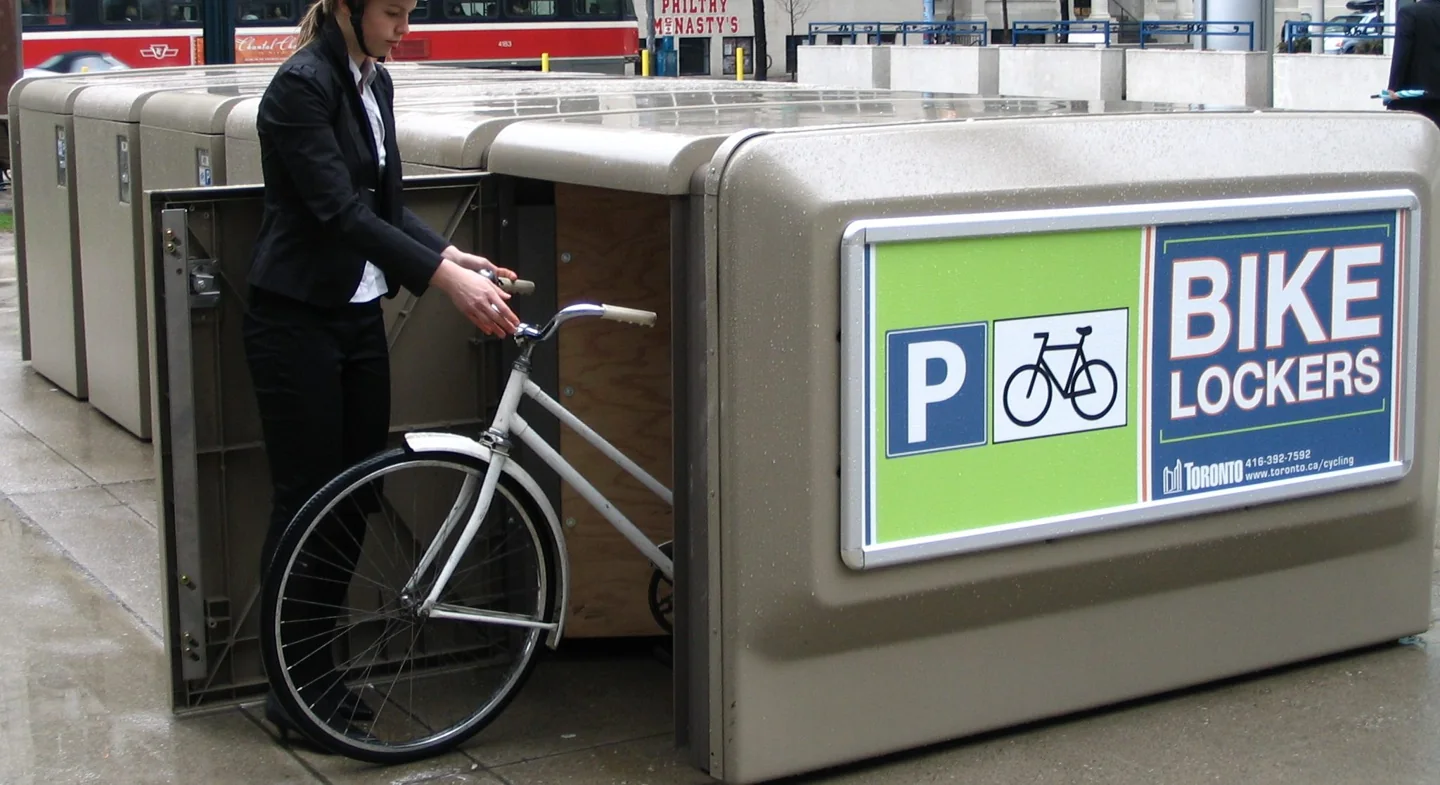 A cyclist places a bicycle in a City of Toronto bike locker