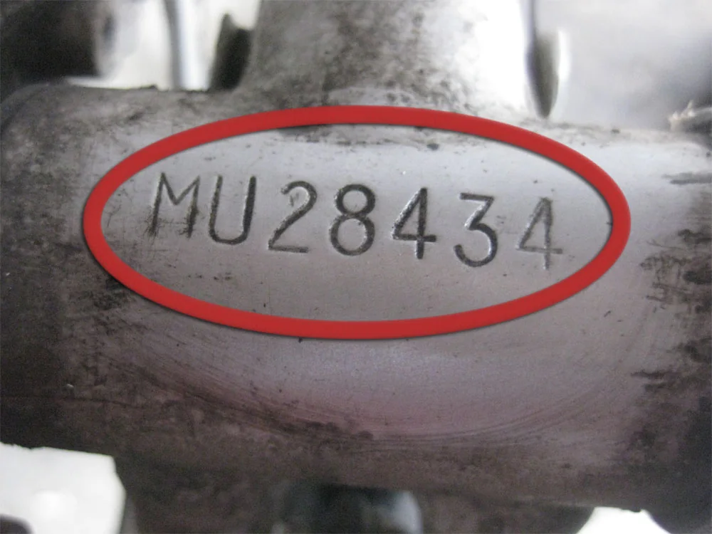 A stamped bicycle serial number circled in red on a metal frame