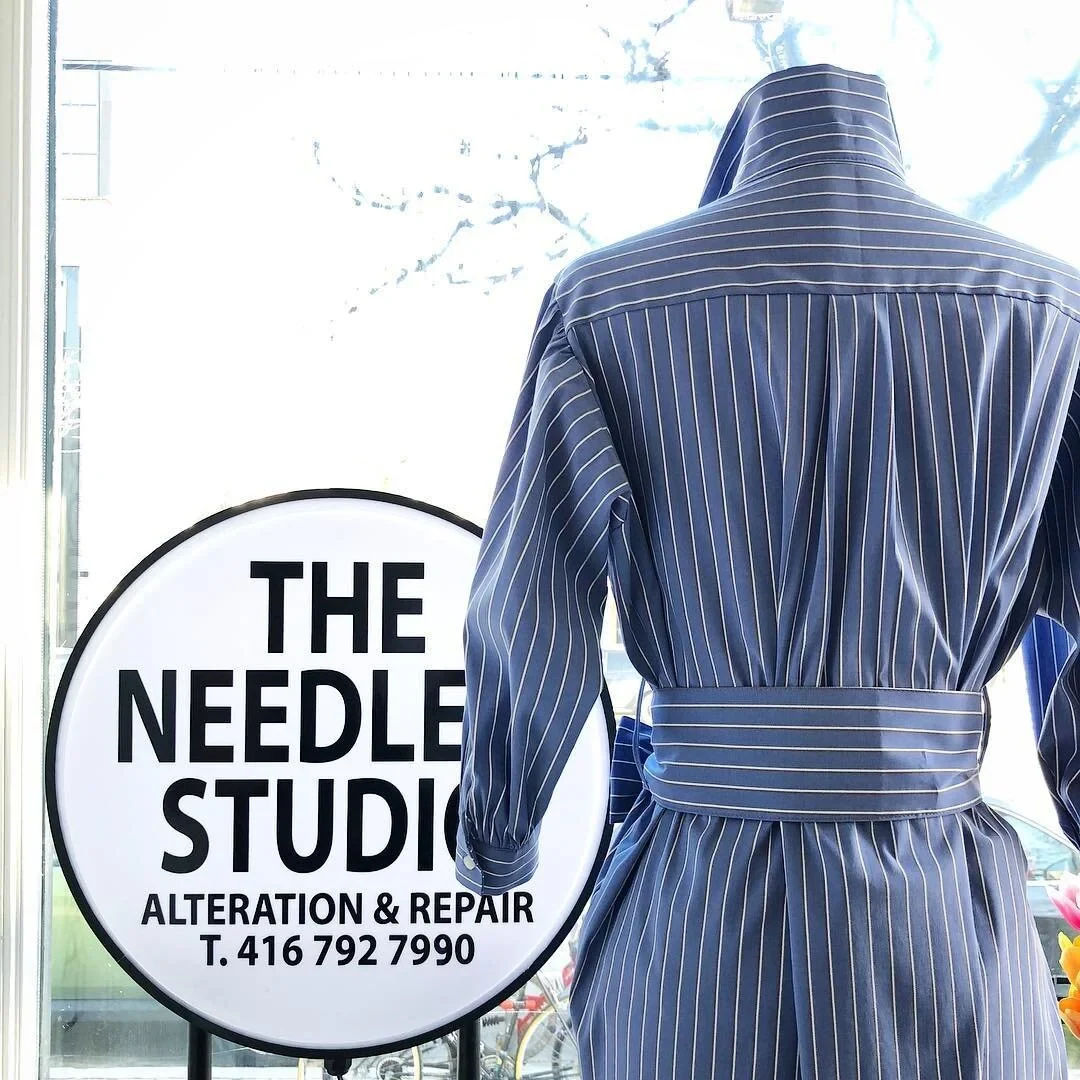 A blue belted garment in The Needle & Studio window