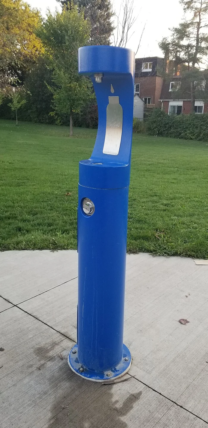 A blue outdoor bottle-filling fountain in a Toronto park