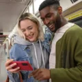 Two riders look at a phone inside a TTC subway train