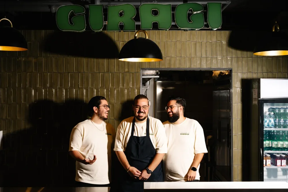 Three members of the Giragi team stand at their counter