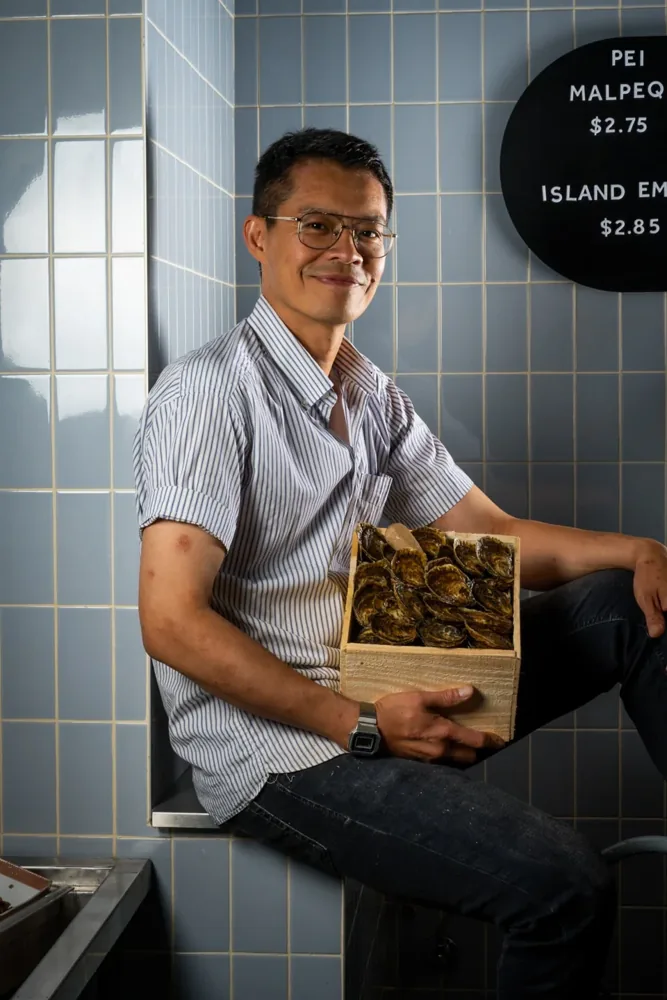 Island Oysters operator holds an open oyster box