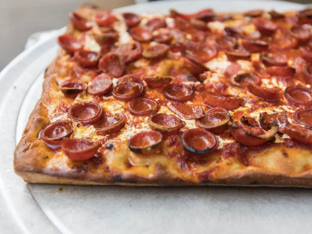 A pepperoni-covered rectangular pizza slice