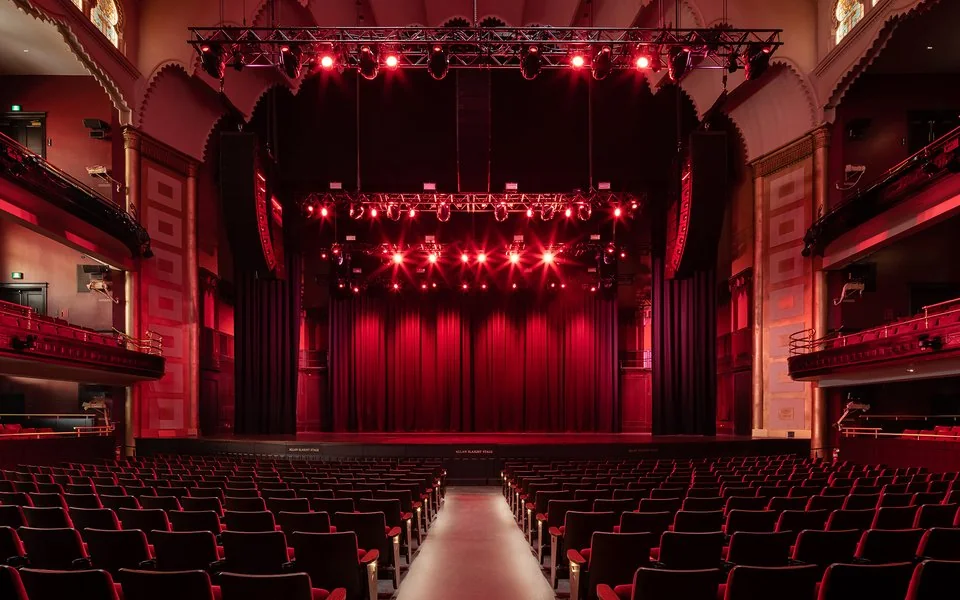 Rows of red seats facing the stage inside Massey Hall
