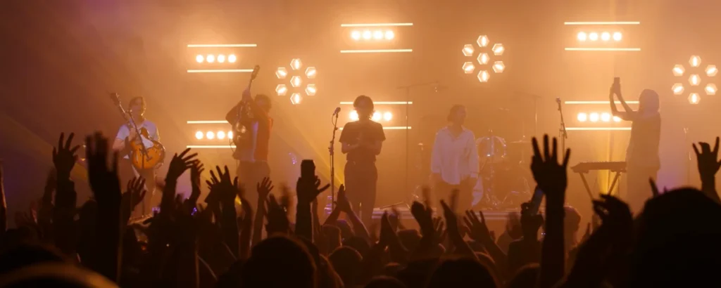 A crowd watching a band under warm stage lights at Massey Hall