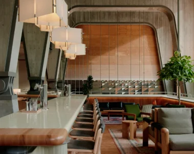 The suspended Lobby bar at Ace Hotel Toronto with wood furniture and tall concrete supports