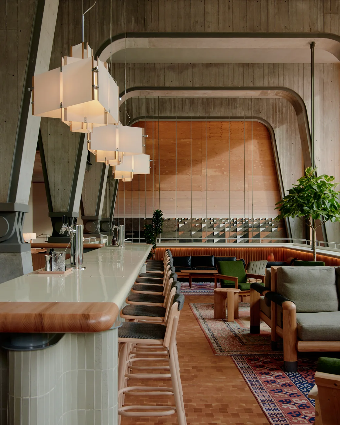 The suspended Lobby bar at Ace Hotel Toronto with wood furniture and tall concrete supports