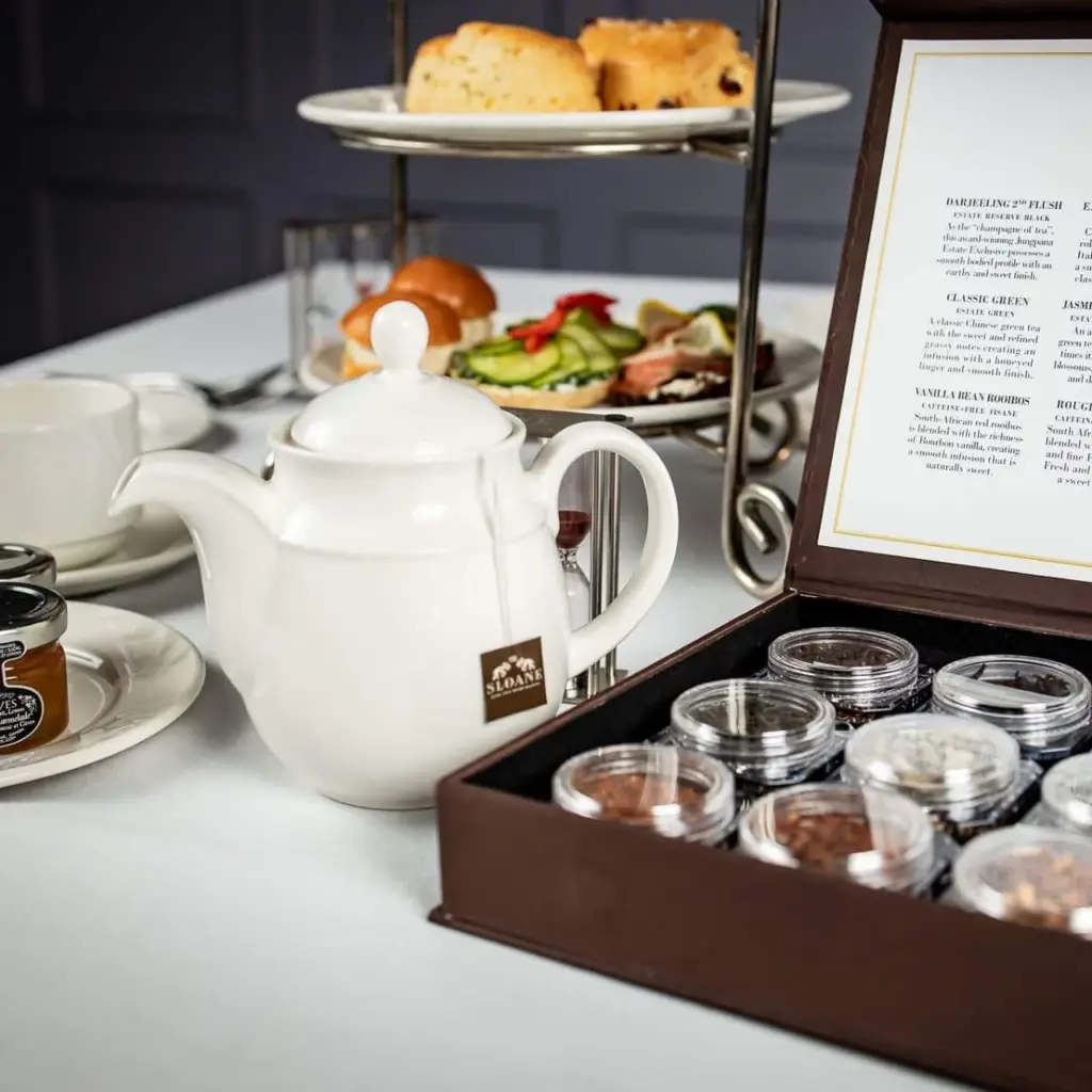 A teapot, tea selection and tiered stand of sandwiches and scones at Old Mill Toronto