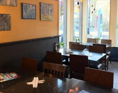 Tables beside a window and paintings inside Outrigger