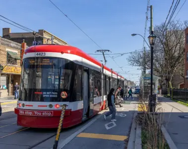TTC streetcar stopped beside traffic on a Toronto street