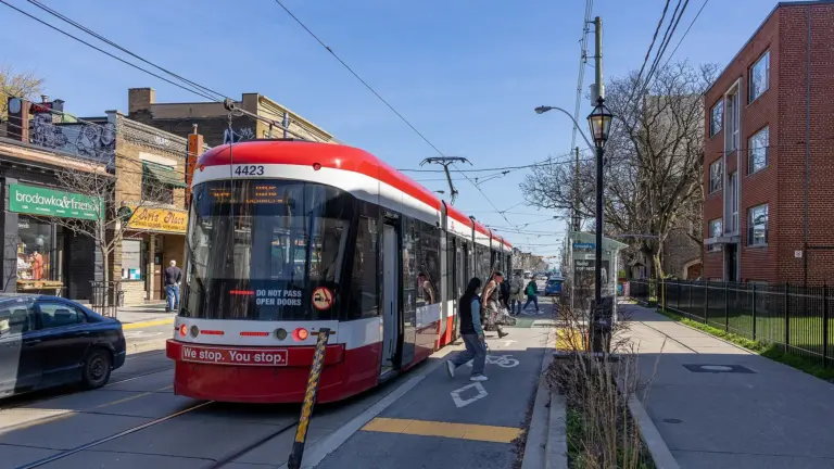 TTC streetcar stopped beside traffic on a Toronto street
