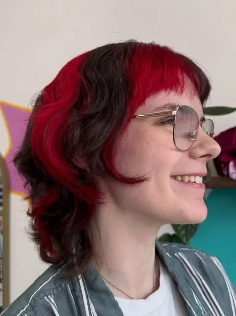 Short dark and red hairstyle with a fringe.