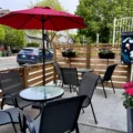 Outdoor tables under a red umbrella at Savoury Grounds