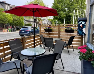 Outdoor tables under a red umbrella at Savoury Grounds
