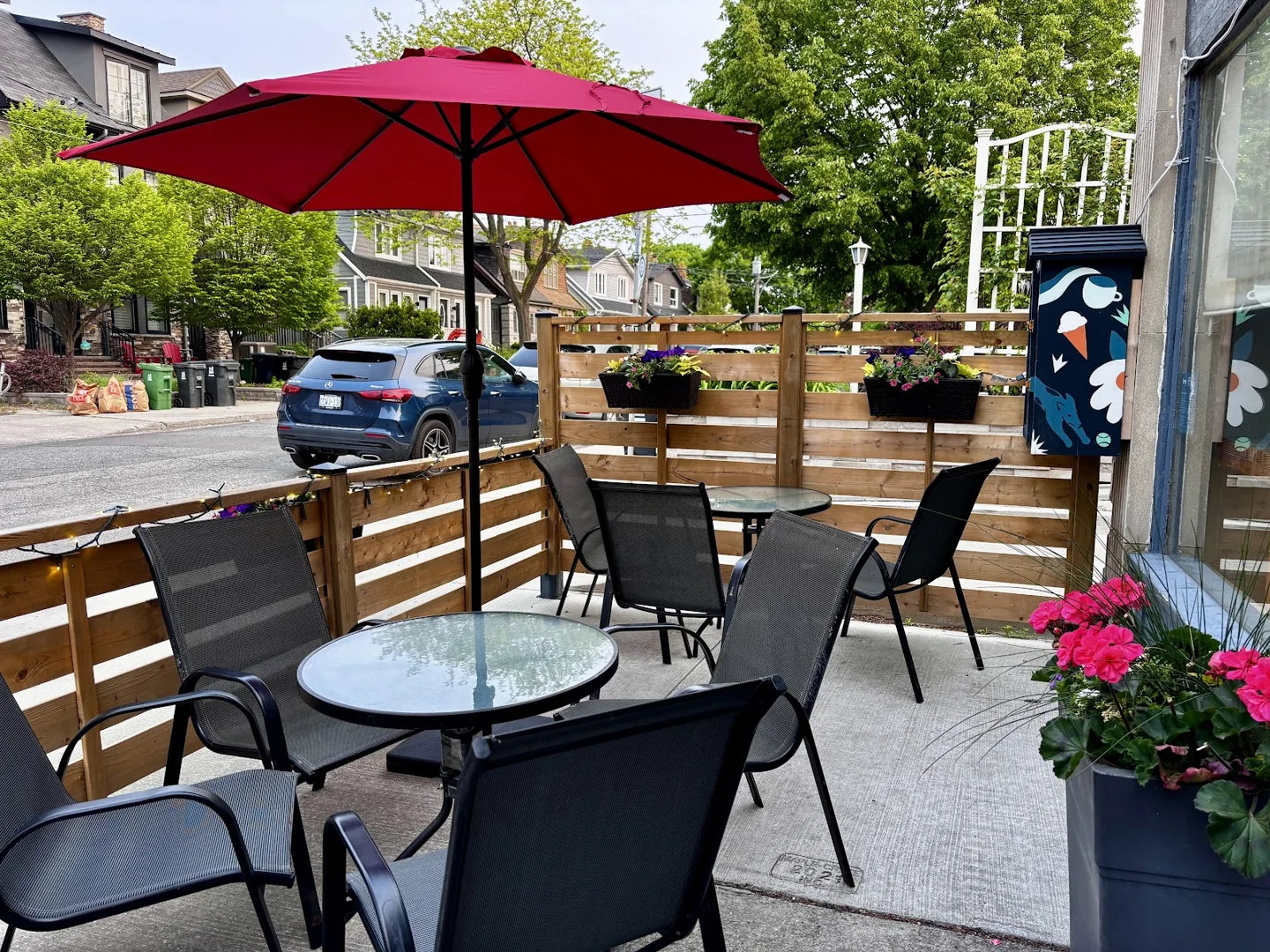 Outdoor tables under a red umbrella at Savoury Grounds
