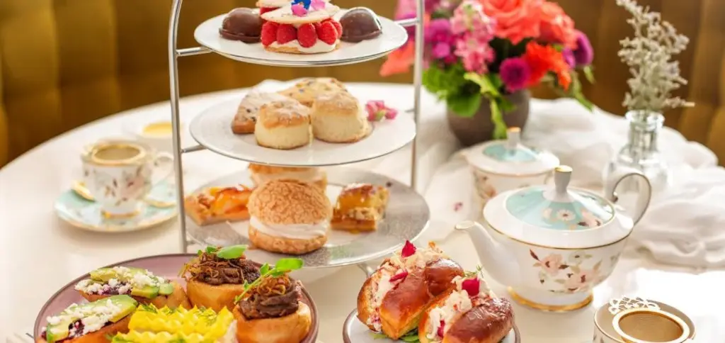 Tiered tea tray with pastries, fruit and savoury bites at Signatures Restaurant