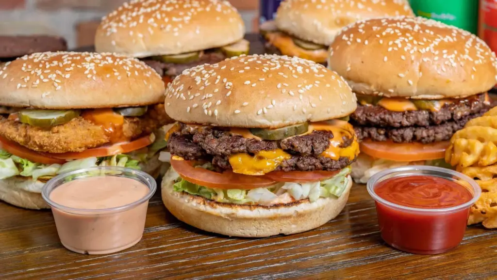 Four vegan burgers with fries and dipping sauces from Soy Boys in Toronto