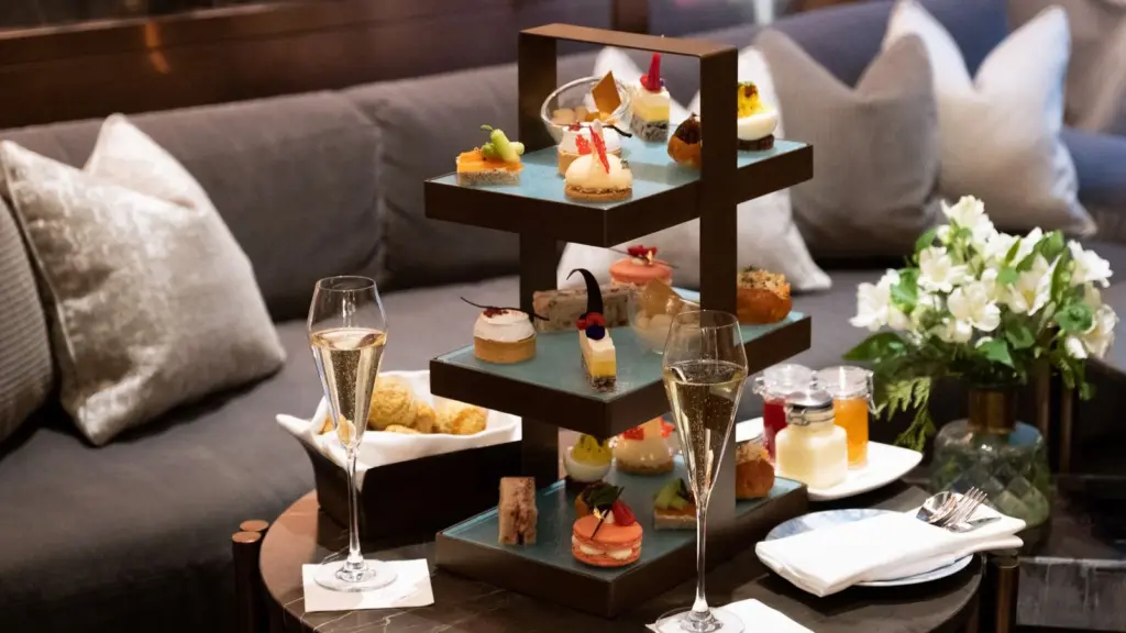 Savouries, scones and pastries on a wooden tiered stand with tea at Astor Lounge