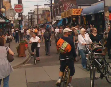 People walking through a car-free Kensington Market street in Toronto