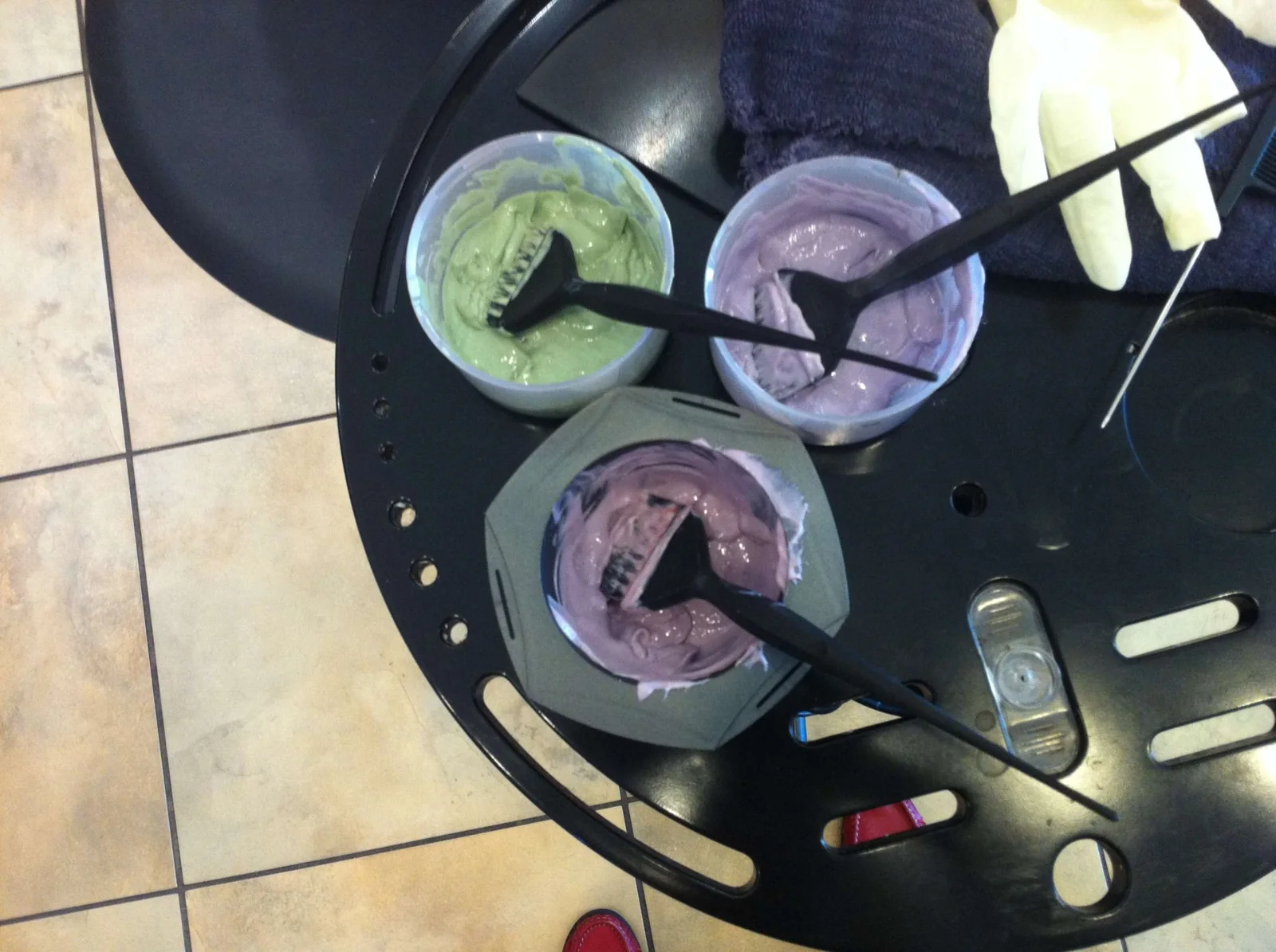 Three bowls with different hair-colour mixtures and application brushes.