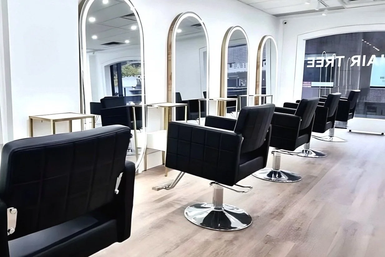 Black salon chairs and arched mirrors at HairTree Yorkville.
