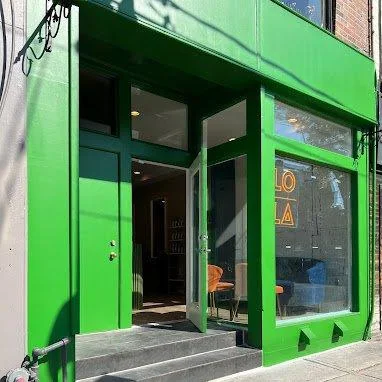 Green storefront of Lola Salon on Queen Street West.