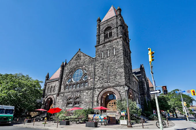 Trinity-St. Paul’s stone church and tower on Bloor Street under a blue sky