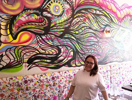 XOLA owner Malinali Fernandez beside the colourful eagle mural