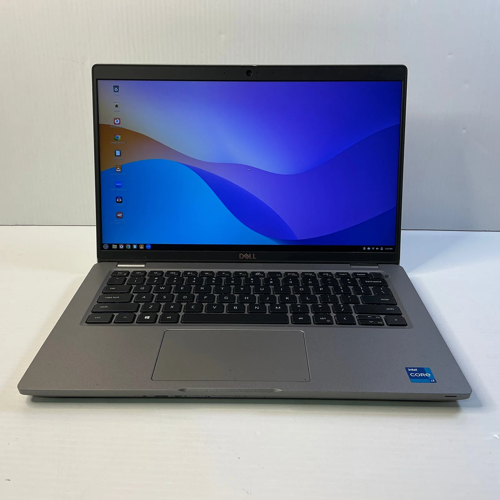 An open Dell Latitude laptop running Linux on a white table.