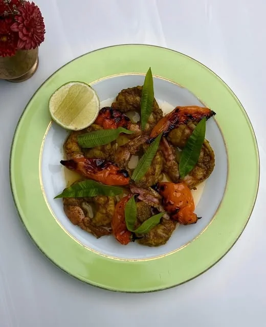 A cooked dish with garnish and lime at Jamil’s Chaat House