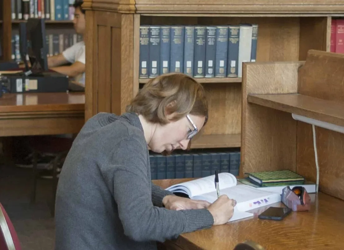 A reader working at a table inside Caven Library at Knox College