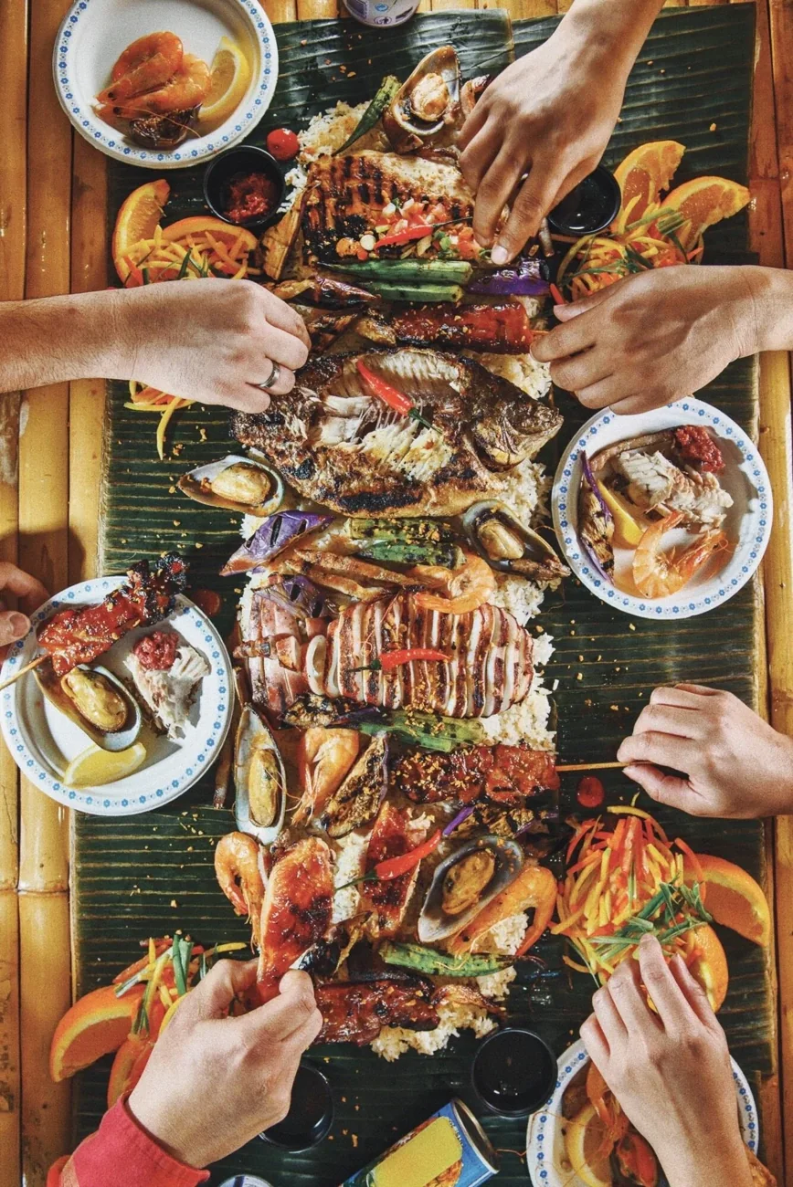 People sharing a Filipino meal served on banana leaves at Tinuno