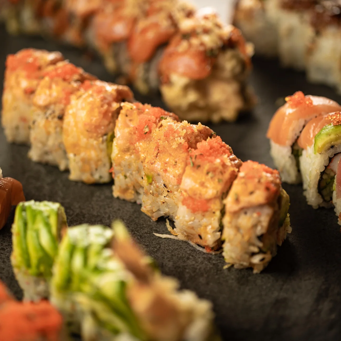 Rows of topped sushi rolls from J San
