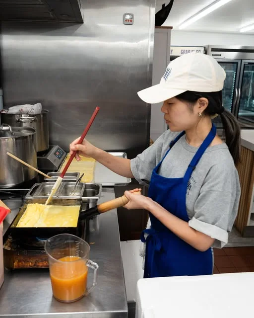 A cook working in the kitchen at Oroshi Fish Co.