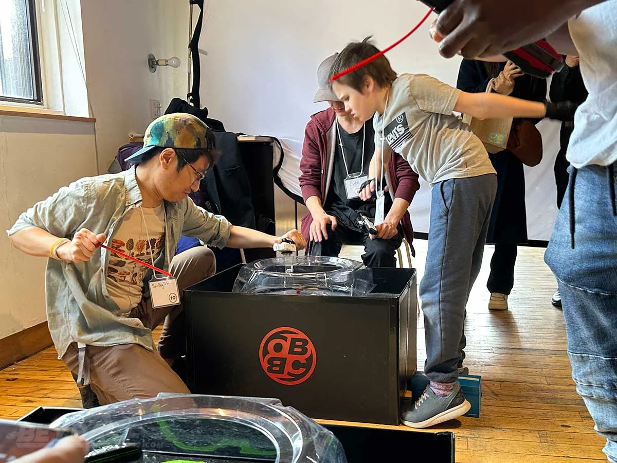 Ontario Beyblade players preparing a launch at an indoor tournament