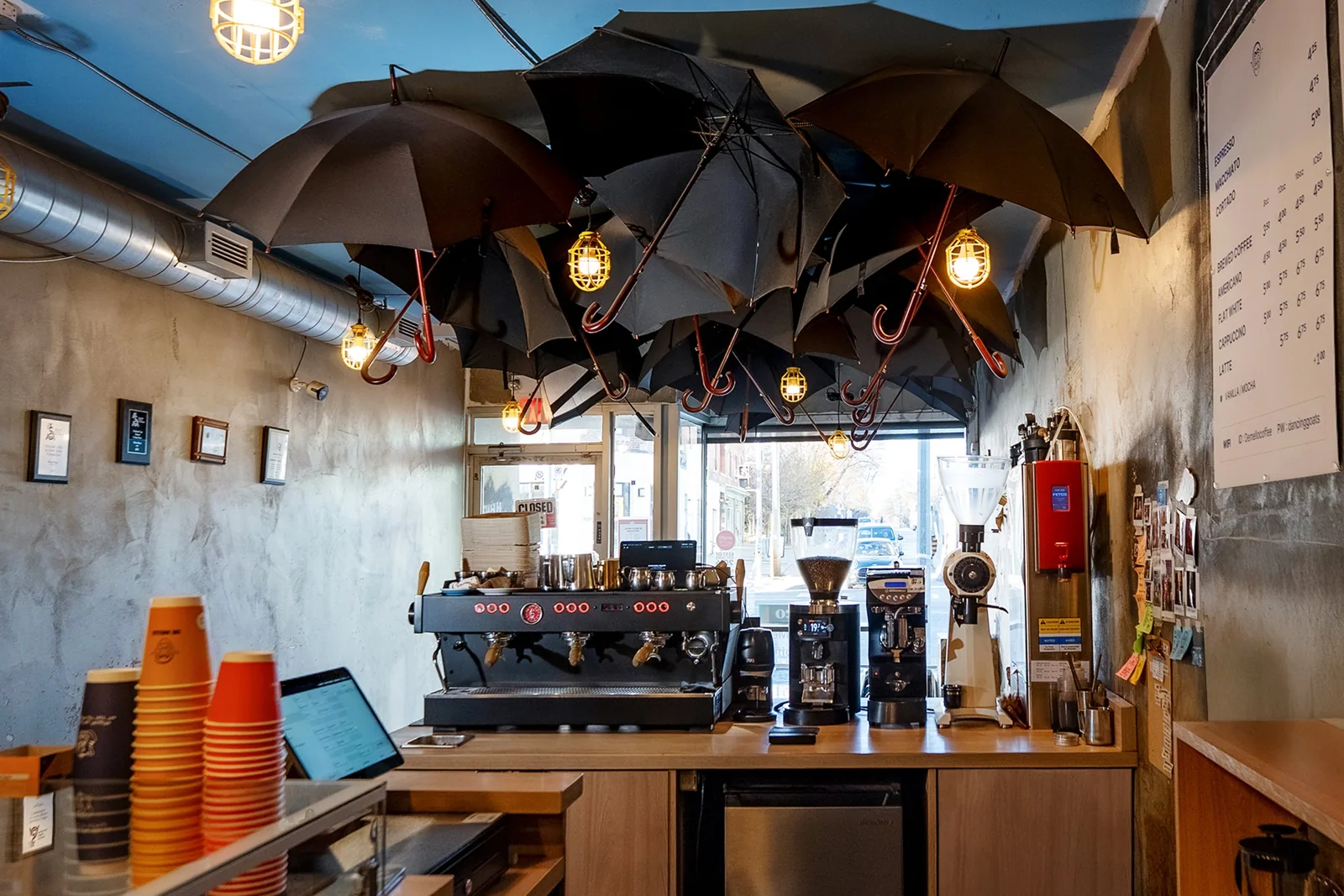Espresso counter and hanging umbrellas at De Mello’s Castlefield café