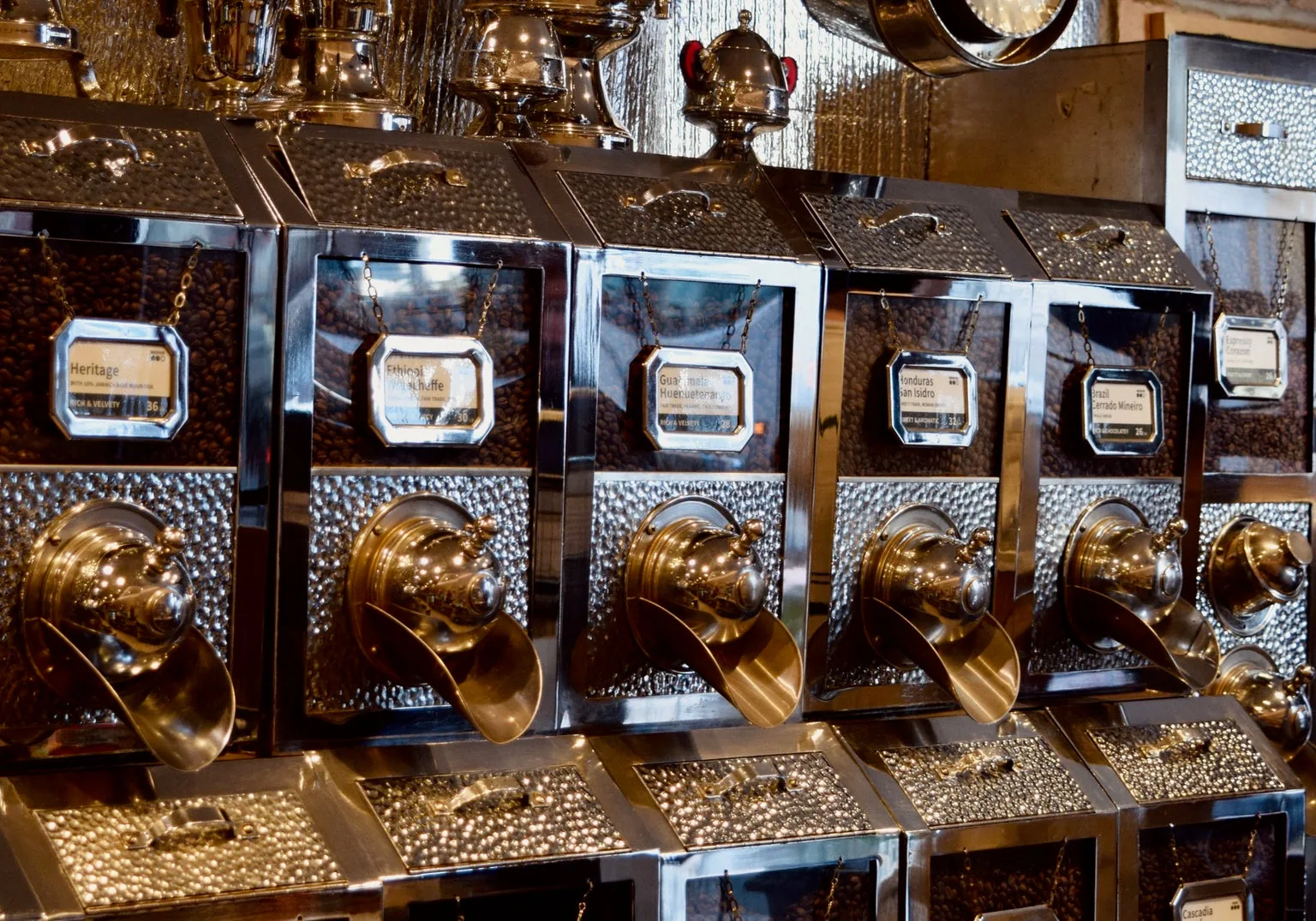 Rows of metal coffee-bean dispensers inside The Coffee Tree Roastery