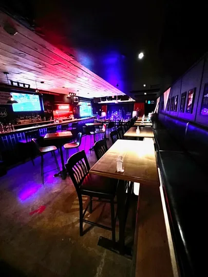 Tables and a long bench in the lower-level room at The Alpine