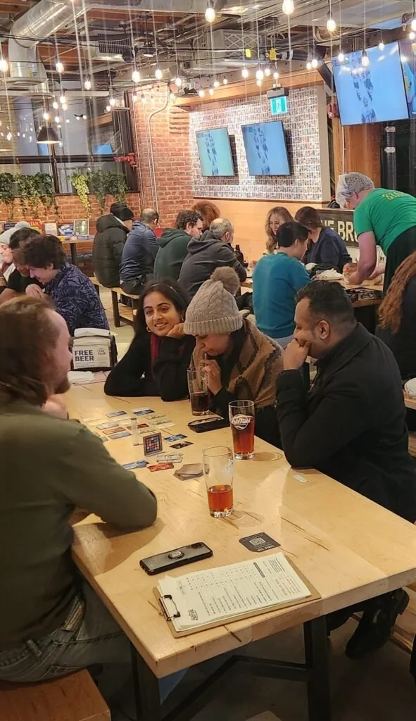 People gathered around a game table in a pub