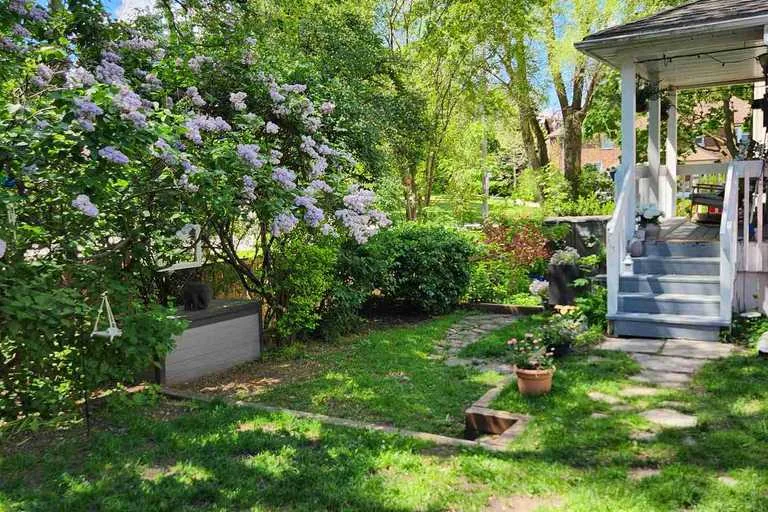 Flowering shrubs, garden path and porch in a private Toronto yard