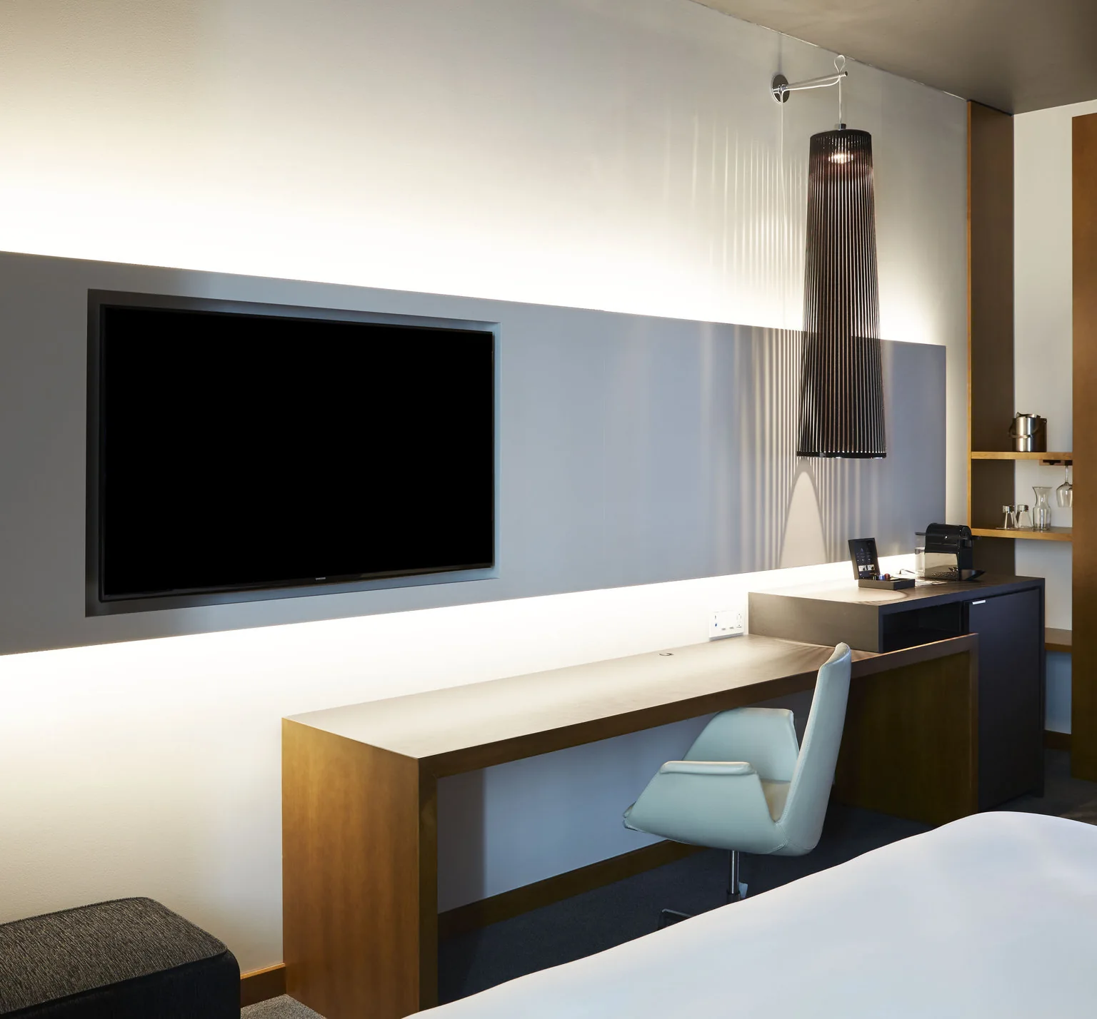Desk, television and part of a bed in a Signature room at Le Germain Toronto Mercer