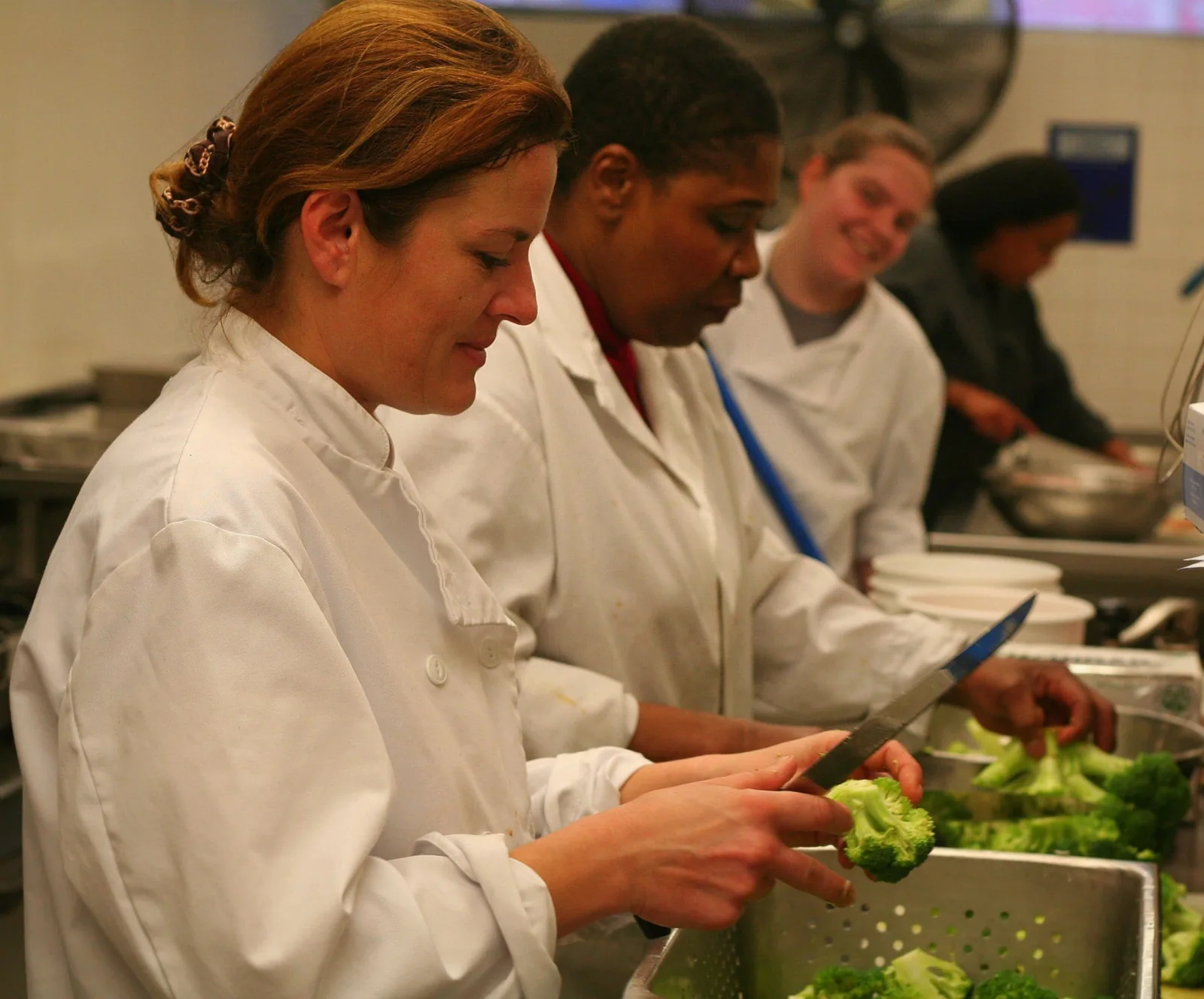 Three kitchen workers preparing vegetables for Fred Victor meals
