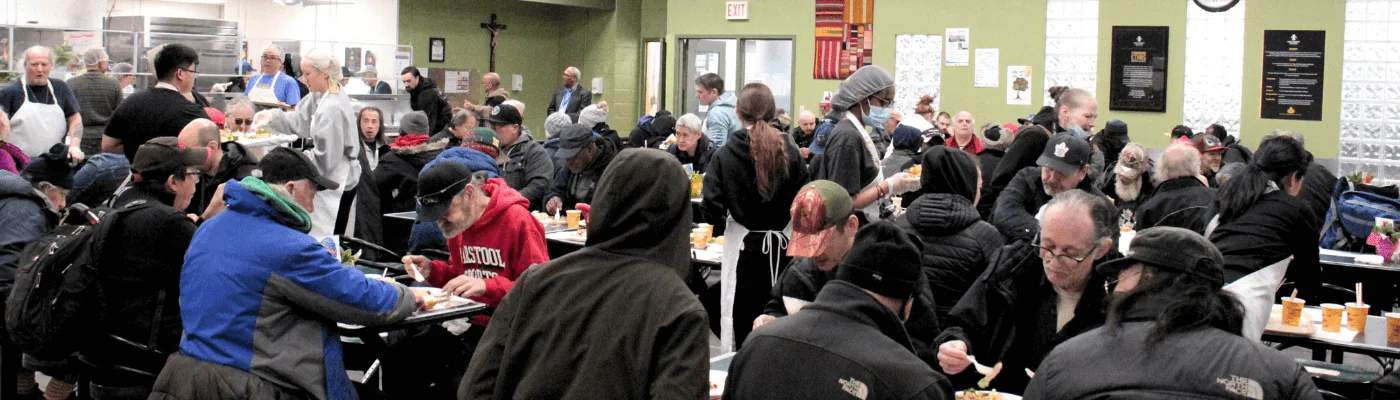 People seated at tables in Good Shepherd’s community dining room