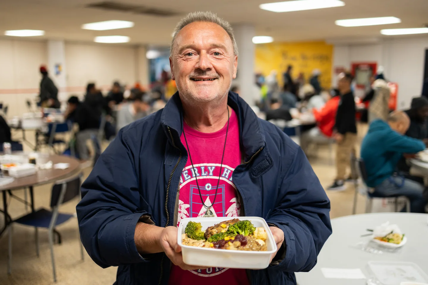 Scott Mission guest holding a container of prepared food