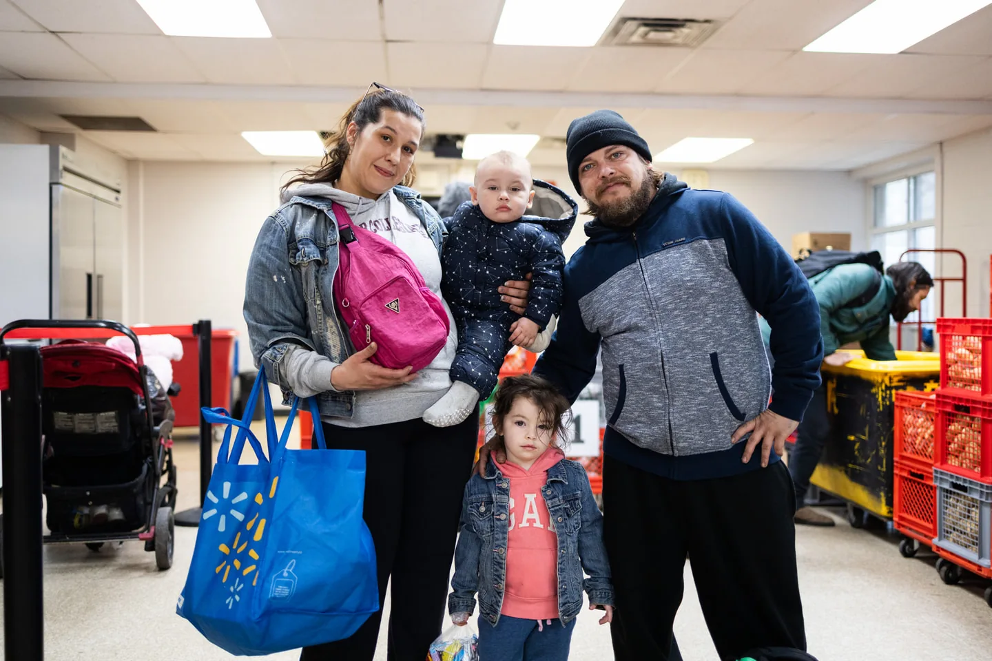 Family standing with grocery bags inside Scott Mission