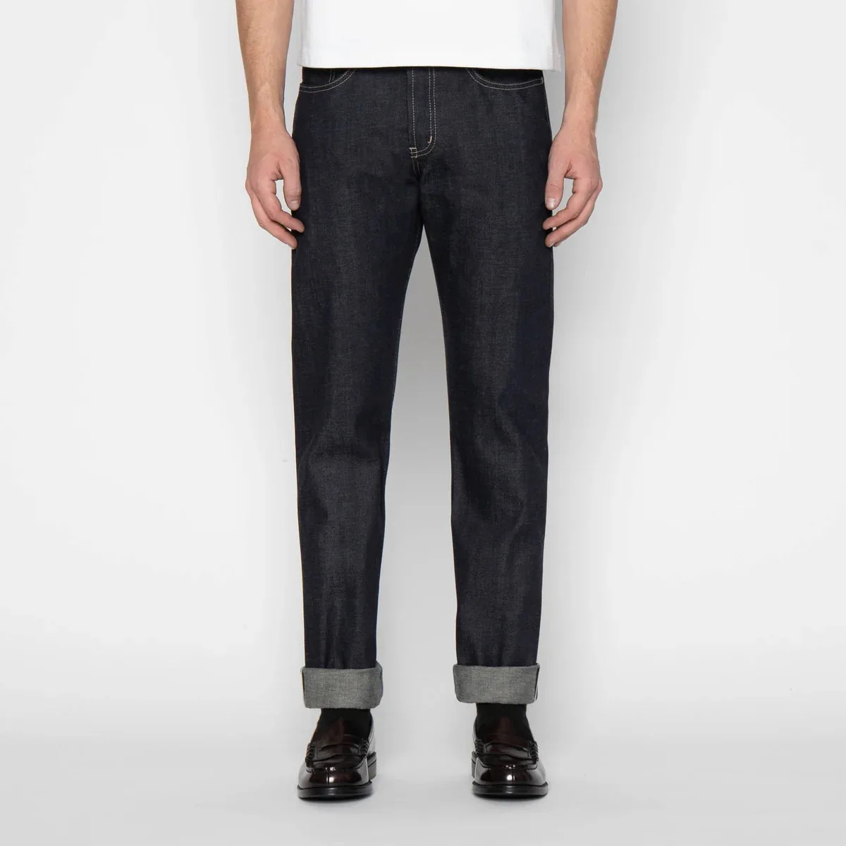 Model wearing straight dark denim jeans with rolled hems