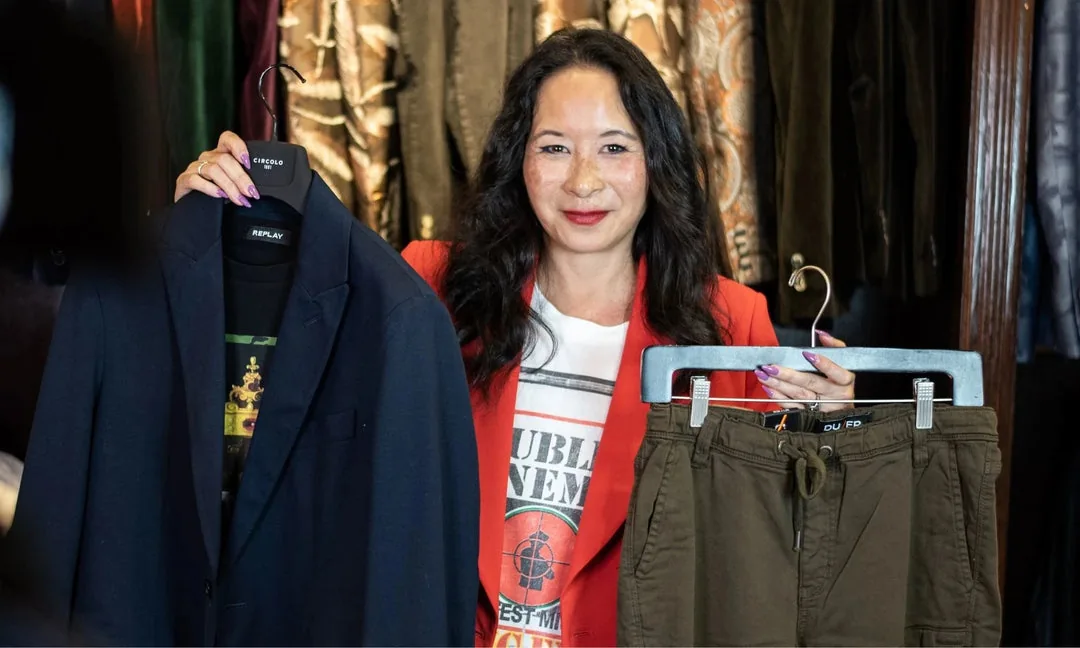 Woman holding up a jacket and trousers in Gotstyle styling photography