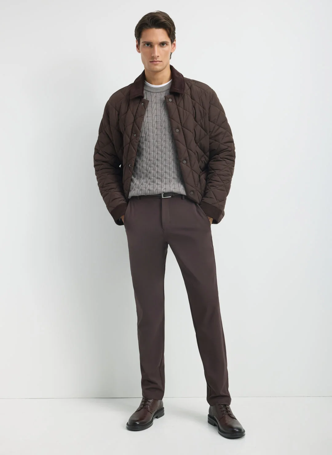 Model wearing brown Kit and Ace trousers and a quilted jacket